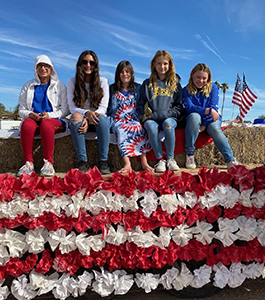 Five happy students on a patriotic float 