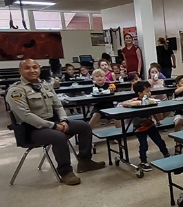 Policeman smiling while visiting students