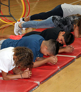 Students participate in an athletic activity on mats