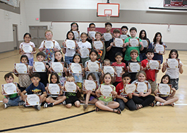 Smiling students pose together with their legs crossed